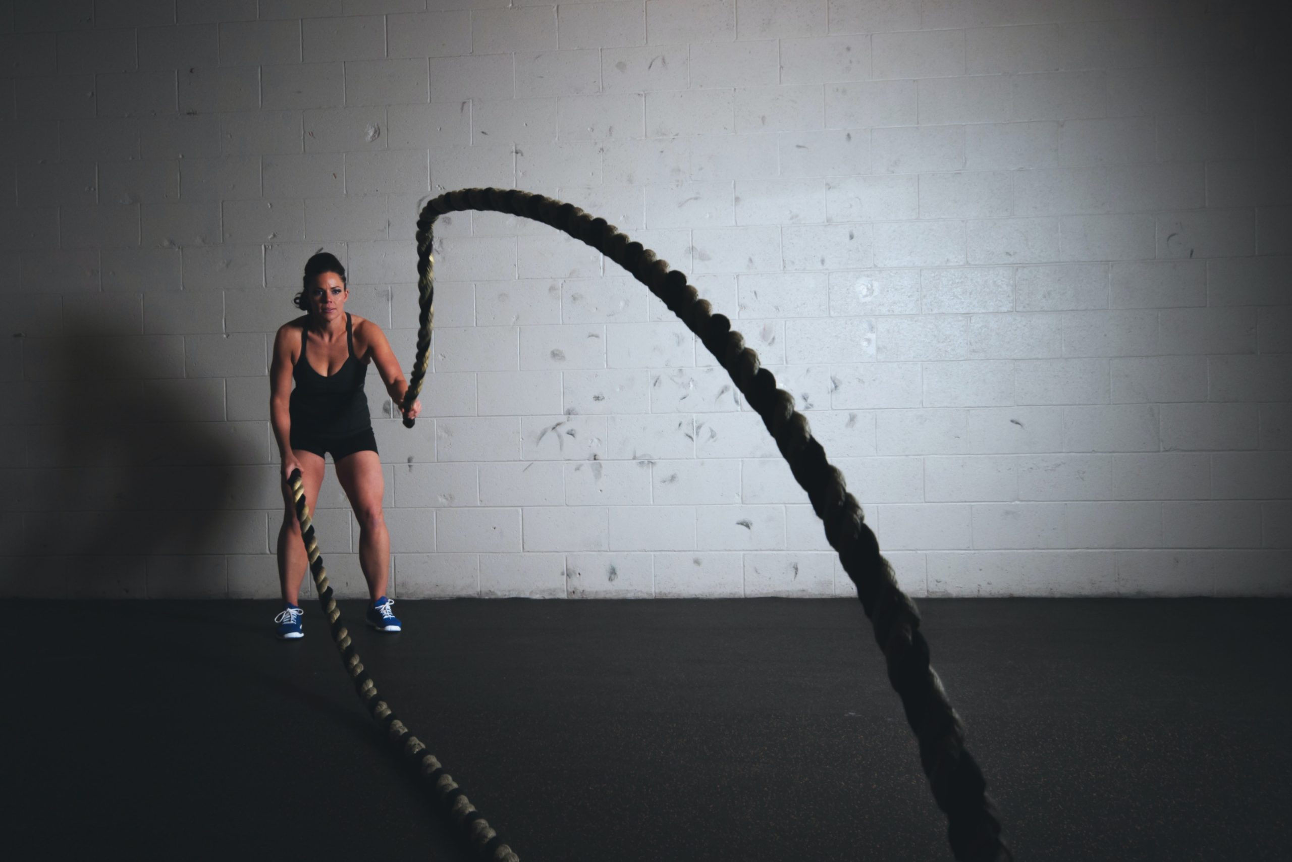 Una chica se ejercita haciendo battle rope